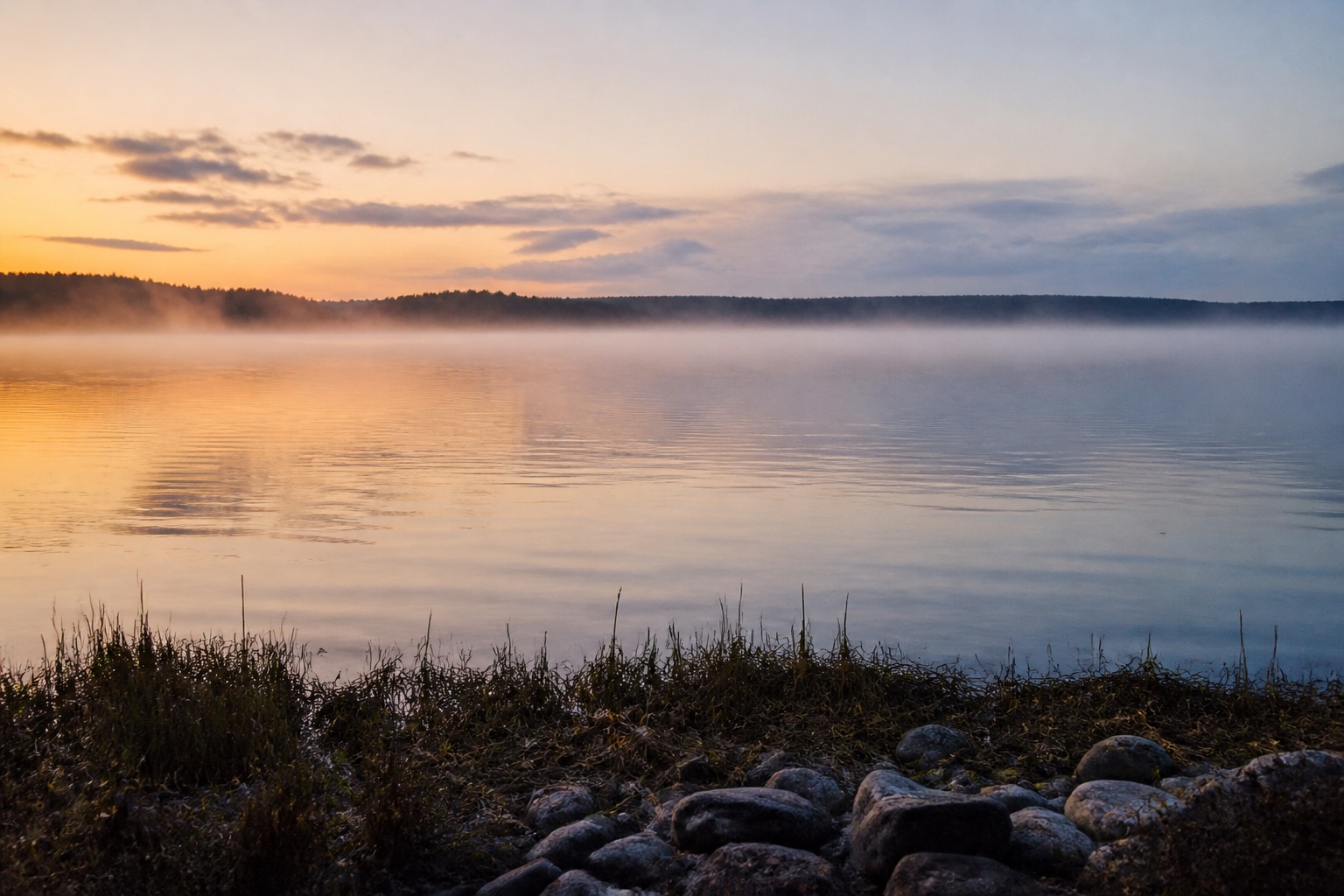 A still morning lake looking out toward the horizon